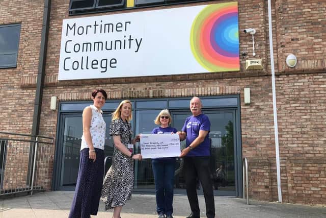 Joanne Thornton, Deputy Head Teacher, and Holly Cooper, Senior Lead Practitioner, presented the Cancer Research UK volunteers, John and Hazel Pickering, with the cheque for almost £3,000.