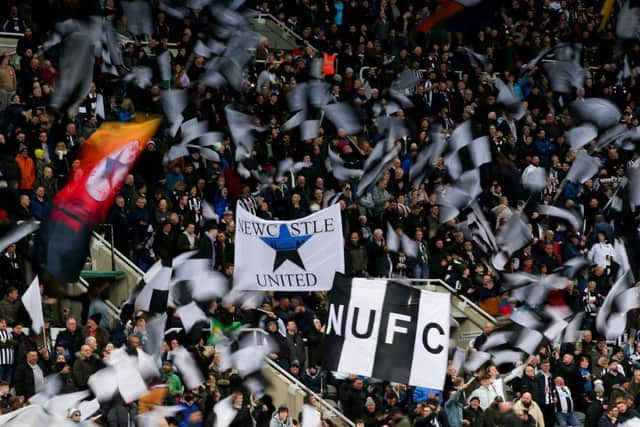 NEWCASTLE UPON TYNE, ENGLAND - FEBRUARY 08: Newcastle United fans wave flags and show their support during the Premier League match between Newcastle United and Everton at St. James Park on February 08, 2022 in Newcastle upon Tyne, England. (Photo by Alex Livesey/Getty Images)