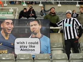 A Newcastle United fan poses for a photo with their flag showing support for Miguel Almiron prior to the Premier League match between Newcastle United and Chelsea FC at St. James Park on November 12, 2022 in Newcastle upon Tyne, England. (Photo by Stu Forster/Getty Images)