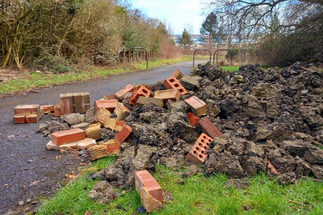 The fly-tippers dumped this rubble over the footpath.
