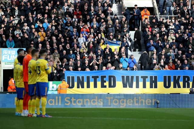 Newcastle United fans hold banners with the Ukrainian flag to indicate peace and sympathy with Ukraine prior to the Premier League match between Newcastle United and Brighton & Hove Albion at St. James Park on March 05, 2022 in Newcastle upon Tyne, England. (Photo by Ian MacNicol/Getty Images)