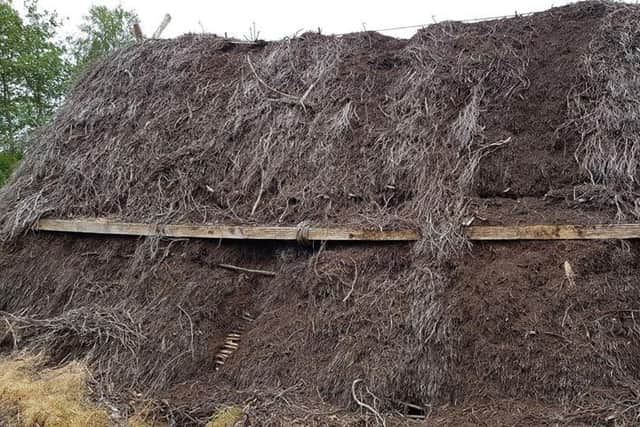 A thatched roof has been badly damaged by vandals.