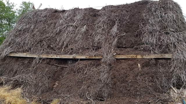 A thatched roof has been badly damaged by vandals.