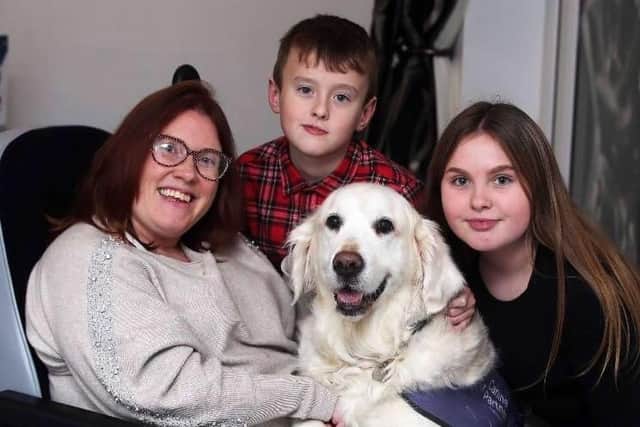 Tara Johnson pictured with her children and a dog from the Canine Partners charity.