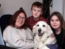 Tara Johnson pictured with her children and a dog from the Canine Partners charity.