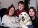 Tara Johnson pictured with her children and a dog from the Canine Partners charity.