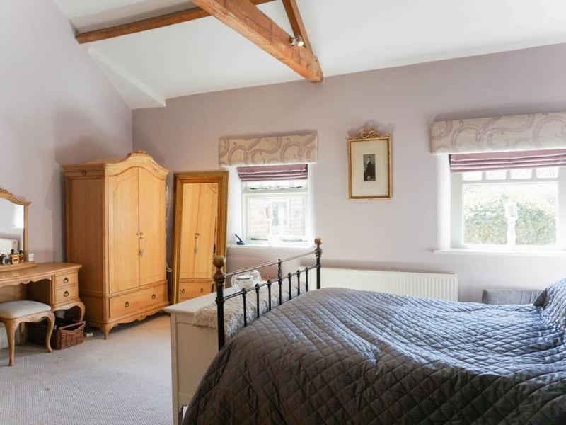 Master bedroom featuring vaulted ceiling and original exposed oak beams with 4 piece ensuite bathroom with underfloor heating.