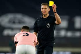 English referee Robert Jones shows a yellow card to Sheffield United's Irish defender Enda Stevens. (Photo by JASON CAIRNDUFF/POOL/AFP via Getty Images)