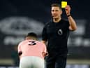 English referee Robert Jones shows a yellow card to Sheffield United's Irish defender Enda Stevens. (Photo by JASON CAIRNDUFF/POOL/AFP via Getty Images)