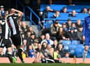 Newcastle United's Swiss defender Fabian Schar (L) points to his elbow as Newcastle United's English defender Dan Burn (C) lays on the pitch after clshing with Chelsea's German midfielder Kai Havertz (R) during the English Premier League football match between Chelsea and Newcastle United at Stamford Bridge in London on March 13, 2022. (Photo by JUSTIN TALLIS/AFP via Getty Images)