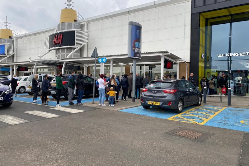 Keen shoppers at Fort Kinnaird have been seen queuing outside H&M and JD Sports on Monday. The line of customers is currently reaching back to the shopping centre's car park as eager shoppers await their turn.