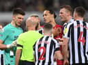 NEWCASTLE UPON TYNE, ENGLAND - FEBRUARY 18: Referee Anthony Taylor talks with goalkeeper Nick Pope of Newcastle United after sending him off for handling the ball outside the box during the Premier League match between Newcastle United and Liverpool FC at St. James Park on February 18, 2023 in Newcastle upon Tyne, England. (Photo by Stu Forster/Getty Images)