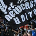 A Newcastle United's fan waves a team's flag as he cheers during a club friendly football match between Newcastle United and Athletic Club at St James' Park in Newcastle-upon-Tyne, northeast England, on July 30, 2022. (Photo by Lindsey Parnaby / AFP) (Photo by LINDSEY PARNABY/AFP via Getty Images)