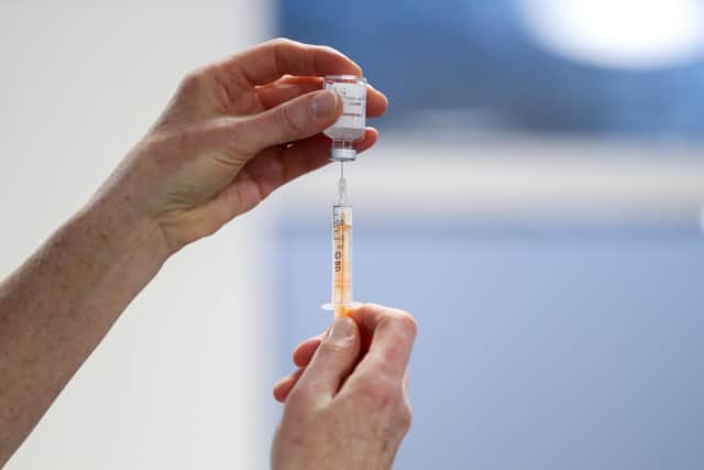 A healthcare worker fills a syringe with a dose of the Oxford/AstraZeneca coronavirus vaccine.