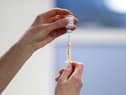 A healthcare worker fills a syringe with a dose of the Oxford/AstraZeneca coronavirus vaccine.
