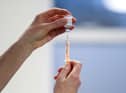 A healthcare worker fills a syringe with a dose of the Oxford/AstraZeneca coronavirus vaccine.