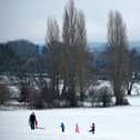 Family play on snow covered hill.