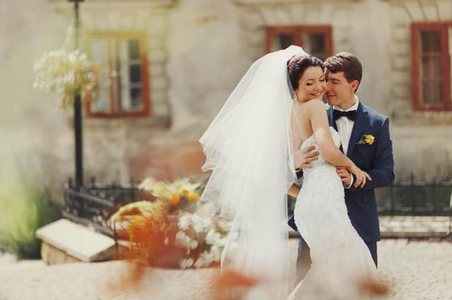 Groom holds bride's waist tenderly at a wedding in Spain