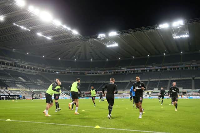 NEWCASTLE UPON TYNE, ENGLAND - DECEMBER 19: General view inside the stadium as Callum Wilson of Newcastle United warms up prior to the Premier League match between Newcastle United and Fulham at St. James Park on December 19, 2020 in Newcastle upon Tyne, England. The match will be played without fans, behind closed doors as a Covid-19 precaution. (Photo by Alex Pantling/Getty Images)