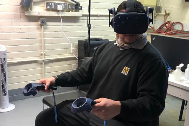 Metro driver Craig Pearson using the VR headset under supervision of Metro Development Officer Alan Dryden