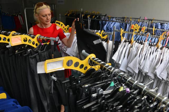 Founder Freema Chambers with the racks of uniform inside the Community School Clothing Scheme store.