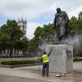 A worker cleans the Churchill statue in Parliament Square that had been spray-painted with the words 'was a racist' on June 08, 2020 in London, England. (Photo by Dan Kitwood/Getty Images)