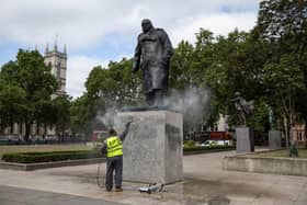A worker cleans the Churchill statue in Parliament Square that had been spray-painted with the words 'was a racist' on June 08, 2020 in London, England. (Photo by Dan Kitwood/Getty Images)