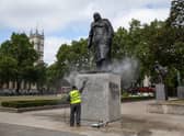 A worker cleans the Churchill statue in Parliament Square that had been spray-painted with the words 'was a racist' on June 08, 2020 in London, England. (Photo by Dan Kitwood/Getty Images)