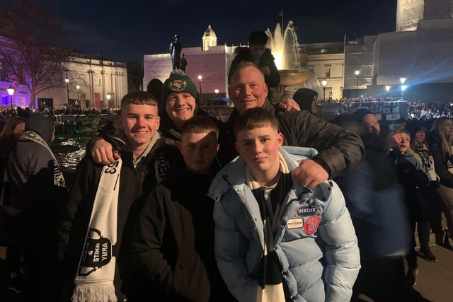 Two families embrace at Trafalgar Square.