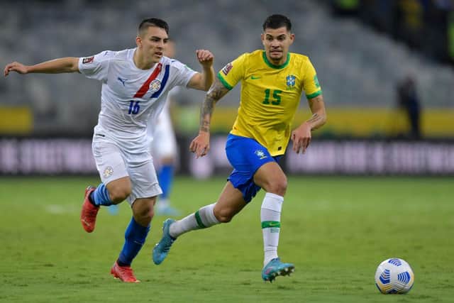 Braian Ojeda of Paraguay and Bruno Guimaraes of Brazil fight for the ball during a match between Brazil and Paraguay as part of FIFA World Cup Qatar 2022 Qualifiers at Mineirao Stadium on February 01, 2022 in Belo Horizonte, Brazil. (Photo by Pedro Vilela/Getty Images)