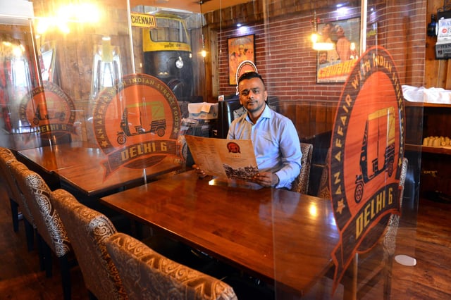 Delhi 6 owner Shah Lalon Amin inside the Ocean Road restaurant which features Covid-19 safety measures such as plastic screens between tables.