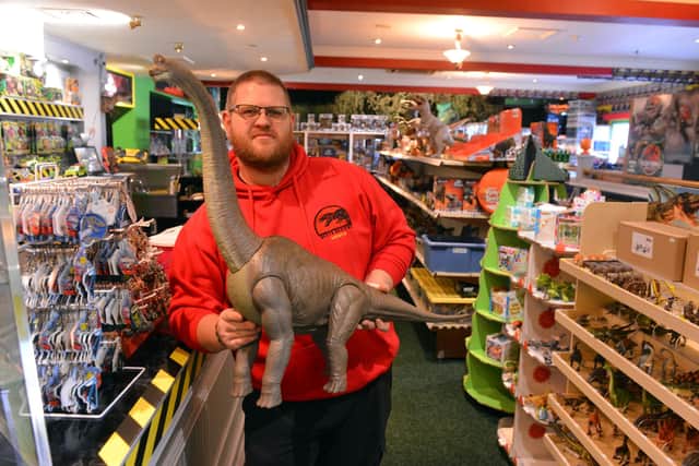 The Dino Den owner Andrew Garthwaite leaning against what was the bar with one of his dinosaur models.