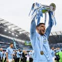 Ruben Dias of Manchester City celebrates with the Premier League Trophy as Manchester City are presented with the Trophy as they win the league following the Premier League match between Manchester City and Everton at Etihad Stadium on May 23, 2021 in Manchester, England.