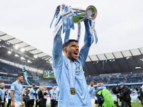 Ruben Dias of Manchester City celebrates with the Premier League Trophy as Manchester City are presented with the Trophy as they win the league following the Premier League match between Manchester City and Everton at Etihad Stadium on May 23, 2021 in Manchester, England.