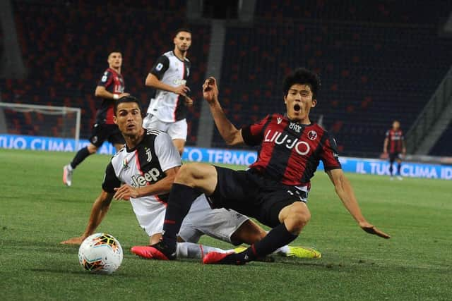 BOLOGNA, ITALY - JUNE 22: Takehiro Tomiyasu of Bologna FC battles for the ball with Juventus player Cristiano Ronaldo during the Serie A match between Bologna FC and Juventus at Stadio Renato Dall'Ara on June 22, 2020 in Bologna, Italy. (Photo by Mario Carlini / Iguana Press/Getty Images)