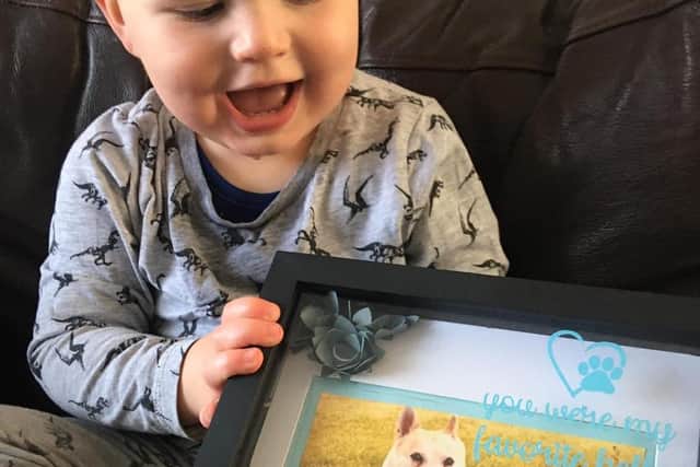 Jesse proudly holds his framed photo of Ellie.
