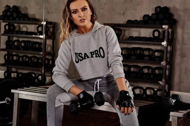 Perrie Edwards tests out the pieces she helped design in the gym.