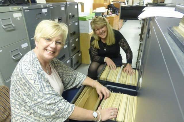 Sisters Julia Northam, left, and Janis Liddle searching for their father's pictures.