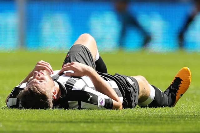 Paul Dummett lies flat out on the opening day after suffering a hamstring injury