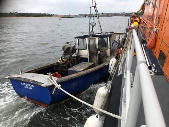 The volunteer team with the small fishing boat in the Tyne. Photo by Tynemouth RNLI.