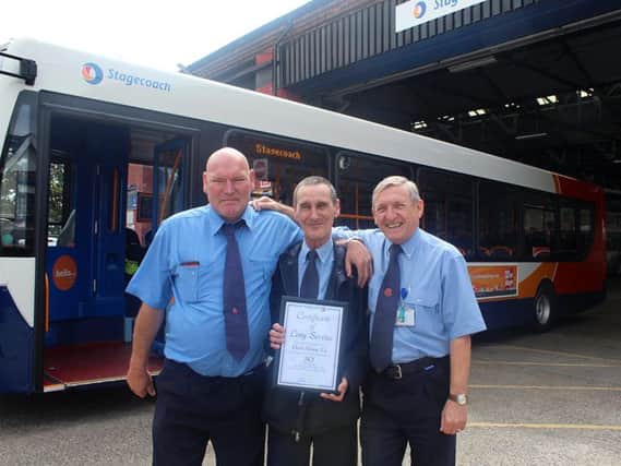 Stephen Martin, David Fleming and Peter French celebrate an accumulation of 100 years working as bus drivers.