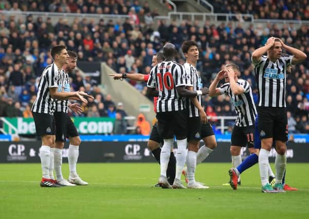Newcastle United players appear dejected after referee Paul Tierney awards a penalty to Chelsea.