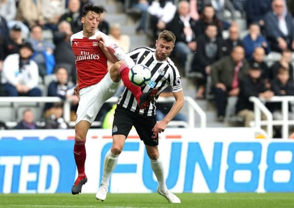 Arsenal's Mesut Ozil (left) and Newcastle United's Paul Dummett (right) battle for the ball during the Premier League match at St James' Park, Newcastle. PRESS ASSOCIATION Photo. Picture date: Saturday September 15, 2018. See PA story SOCCER Newcastle. Photo credit should read: Owen Humphreys/PA Wire. RESTRICTIONS: EDITORIAL USE ONLY No use with unauthorised audio, video, data, fixture lists, club/league logos or "live" services. Online in-match use limited to 120 images, no video emulation. No use in betting, games or single club/league/player publications.