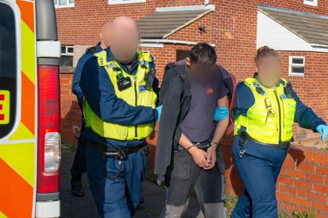 Police lead away a man during the raids in South Tyneside on Wednesday