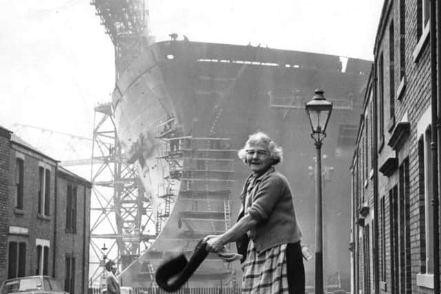 Daily chores being carried out in 1969 in the shadow of the tanker Esso Northumbria, which is to be launched on the Tyne by Princess Anne.