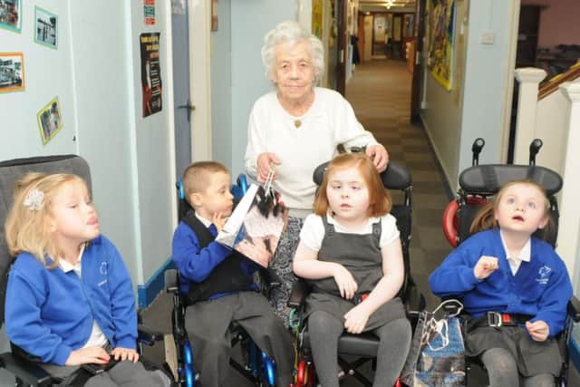 SPECIAL TREAT ... Oakleigh Garden School get early Chritmas present from The Charity Club. Mena Larkin at 102 years old presenting suprises to left, Neve Rees-Burton, Keiron Perkins Charlotte Atkinson and Rebecca Rumney.