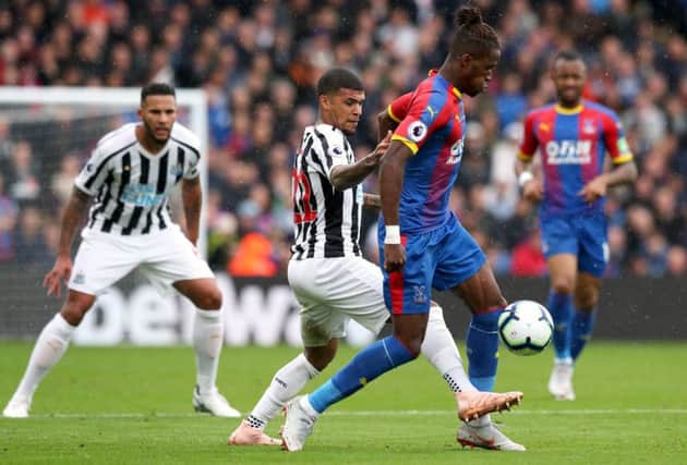 Jamaal Lascelles watches on as DeAndre Yedlin challenges Wilfried Zaha.