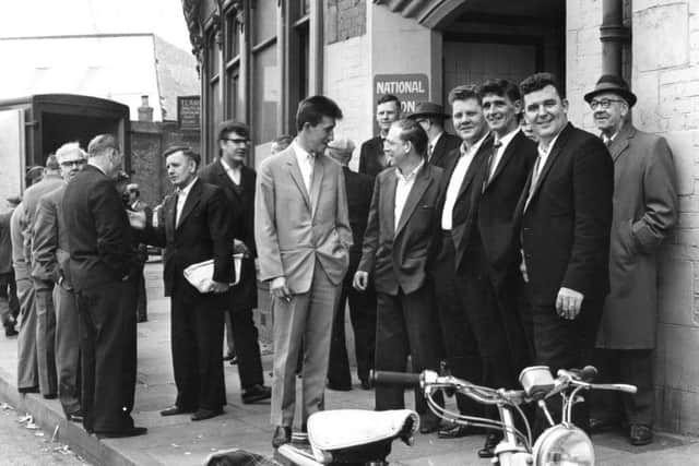 South Shields seamen discuss the report of the court of inquiry into the shipping dispute outside the offices of the NUS at the Mill Dam. 1966.