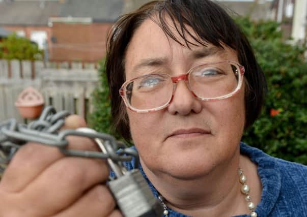 Annette Eversson holding the lock and chain that was cut off her Mobility Scooter. Picture by FRANK REID