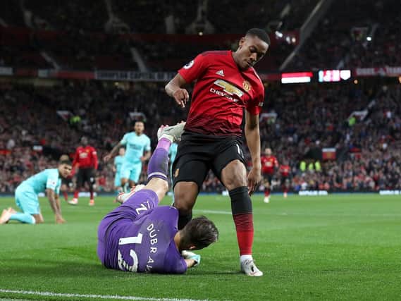 Newcastle United goalkeeper Martin Dubravka saves from the feet of Manchester United's Anthony Martial. Photo credit: Martin Rickett/PA Wire